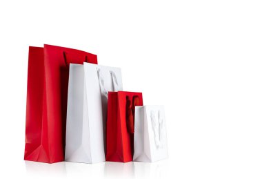 Various sizes of holiday shopping gift bags on isolated white background. Red and white color
