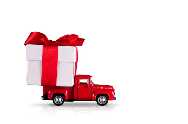 Red car with a gift box on a isolated white background. The concept is the delivery of gifts for the holidays, Valentines Day, International Womens Day, February 14, March 8. Shopping, sale — Stock Photo, Image