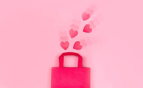 Online nákupní koncept. Horní pohled na dárkové tašky a růžové papírové srdíčka na růžovém pozadí s zvlněným efektem, kopírovací prostor, plochý ležel. Pozadí pro Valentýna, Narozeniny, Den matek — Stock fotografie