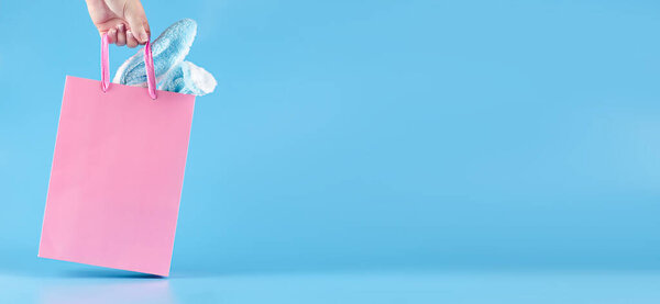 Широкий баннер на синем фоне. Подарочный пакет в руке. 
