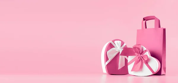 분홍색 배경에 하트 모양의 선물 상자를 가진 배너입니다. 여성의 날 선물 개념, 텍스트를 위한 공간 이 넓은 깃발. 개념 - 승진, 판매, 쇼핑. 스톡 이미지