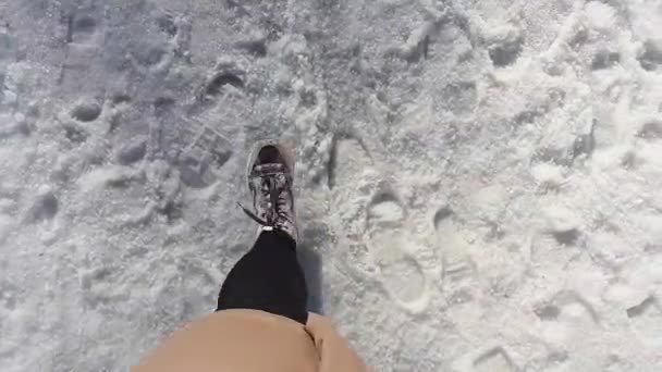 4k απόθεμα βίντεο closeup κορυφαία άποψη. Από την οπτική γωνία, βίντεο για το πρώτο άτομο. Επίπεδη διάταξη. Μια γυναίκα περπατάει στο χιόνι. — Αρχείο Βίντεο