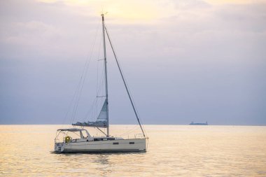 Denizde küçük özel bir yat. Güzel bir turkuaz dalgası ve hafifçe gerilmiş bulutları var.