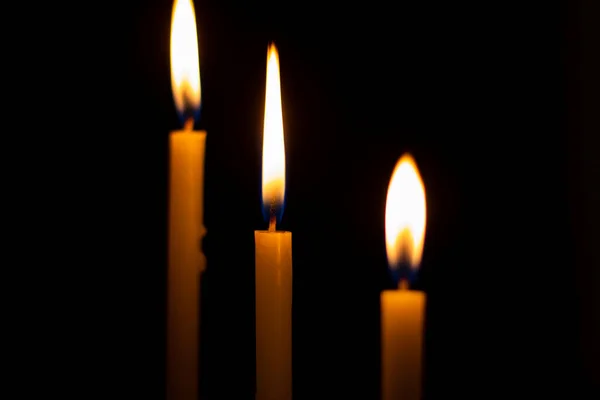 明亮的烛焰模糊了背景 在黑色背景上点燃蜡烛A 在黑暗中手牵着蜡烛祈祷 — 图库照片