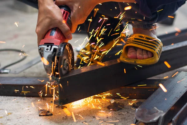 İş yerinde güvenlik eldiveni olmadan. İnşaat işçileri çalışırken eldiven ve güvenlik ayakkabısı giymezler. İş yeri güvenli değil. ayakkabılara odaklan