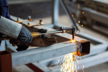 Kaynak, gaz ve oksijen metalleri kaynaştırır ve keser. İçerik güvenlik aksesuarları. Metal kesim, fabrikada asetilen meşaleli çelik. Ateş tanecikleriyle çalışırken koruyucu eldiven tak