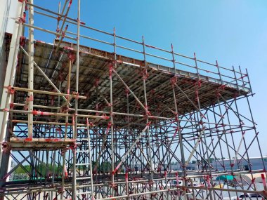 Gökyüzü arkaplanlı iskele. Sanayi tesislerinin inşası için konsept. İnşaatta kullanılan iskele.