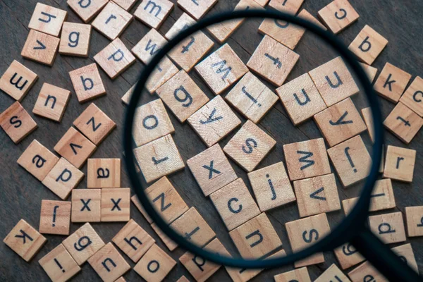 English alphabet made of square wooden tiles with the English alphabet scattered on wood background. The concept of thinking development,grammar.