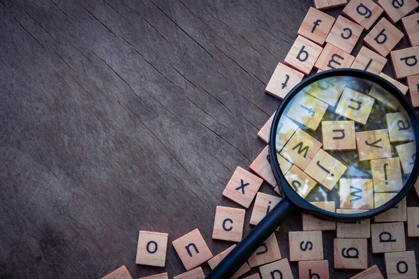 English alphabet made of square wooden tiles with the English alphabet scattered on wood background. The concept of thinking development,grammar.