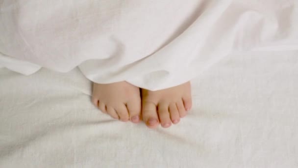 Child Moves His Legs Covers Childrens Morning Awakening Close Video — Vídeo de Stock