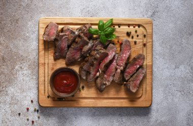 Az pişmiş biftek, tahtada dilimler. Yukarıdan görüntüle.