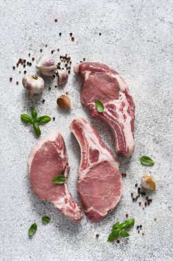 Taze et. Hafif arka planda baharatlar olan tahta bir tahtadaki kaburgalar. Domuz bifteği.