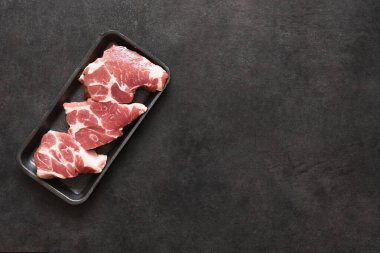 Siyah arka planda tepsisi olan üç biftekli biftek. Pulp, fileto. Taze et..