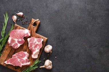 Siyah arka planda baharatlı, tuzlu ve biberiyeli biftek. Taze et..