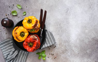 Doldurulmuş biber. Pirinç ve kıymalı kırmızı biber. Beton bir arka planda dökme demir bir tavada pişmiş biber. Akşam yemeği