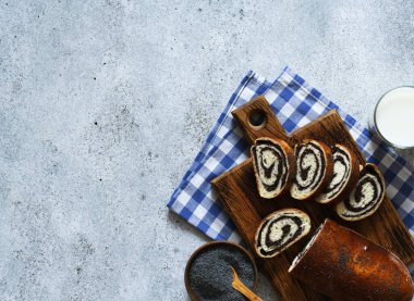 Haşhaş tohumlu ve sütlü turta. Tahta bir üst manzarada yuvarlan.