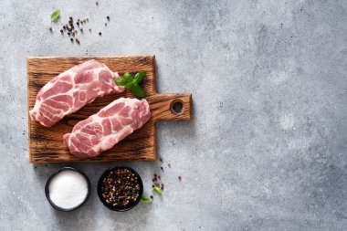 Çiğ taze et. Tahta tahtada baharatlı ve fesleğenli domuz bifteği..