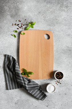 Boş ahşap tahta. Beton bir arka planda baharat ve keten peçeteli karatahta.