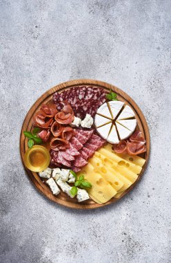 Lezzetli ahşap tabak. Brie peyniri, mavi peynir, salam, tahta üzerinde jambon..