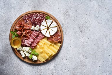 Lezzetli ahşap tabak. Brie peyniri, mavi peynir, salam, tahta üzerinde jambon..