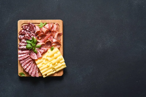 黒石の背景に木製の正方形の板にチーズ プロシュート サラミ おいしさ — ストック写真