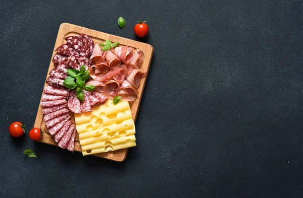 黒石の背景に木製の正方形の板にチーズ プロシュート サラミ おいしさ ストック写真