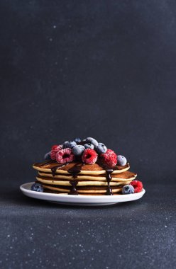 Üzerinde ahududu, yaban mersini ve çikolata sosu olan krepler. Böğürtlenli krep.