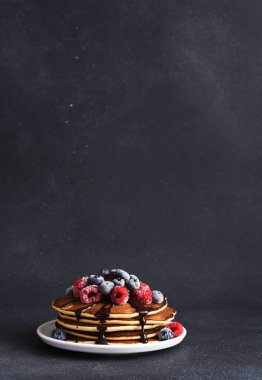 Üzerinde ahududu, yaban mersini ve çikolata sosu olan krepler. Böğürtlenli krep.