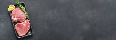 Siyah masada baharat tepsisinde taze domuz bifteği.