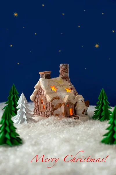 冬休みのグリーティングカード 星空を背景に 折り紙モミの木の雪の森の中のおとぎ話の小屋のショット ポストカード ポスター 碑文と招待状メリークリスマス — ストック写真