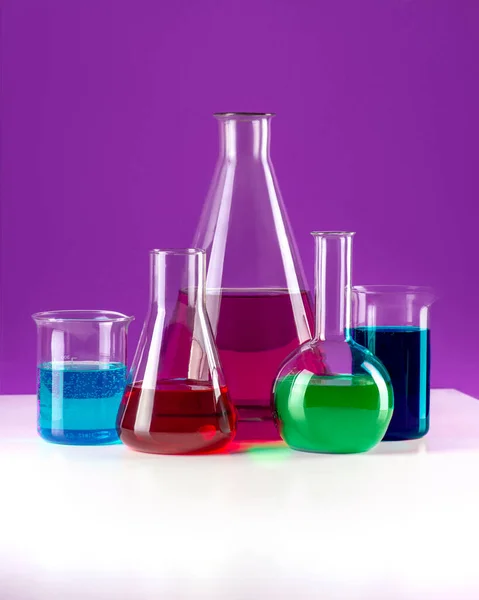 Fiaschette Laboratorio Con Liquido Colorato Sono Fila Uno Sfondo Viola — Foto Stock