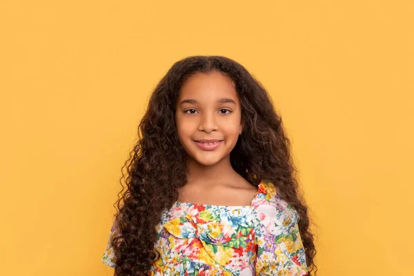 在黄色背景上挂起一个黑皮肤 留着一头长长的卷发 头戴五颜六色的年轻微笑女孩的画像 — 图库照片