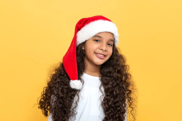 提起一个深色皮肤的年轻姑娘的画像 她的头发长卷曲 头戴一顶黄色的圣诞老人帽 — 图库照片