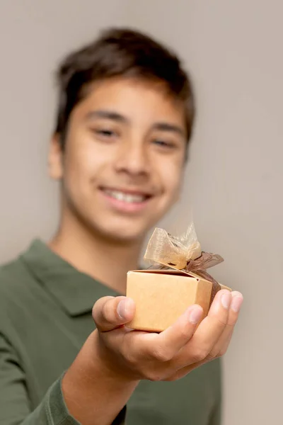 Shot Young Boy Giving Gift Holding Out Beige Gift Box — Zdjęcie stockowe