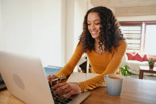 Multi-culturele vrouw gelukkig werken vanuit huis op haar laptop. Jong professioneel werken op afstand in modern appartement — Stockfoto