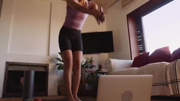 Jonge, mooie multi-culturele dame die online yoga beoefent in de woonkamer — Stockvideo