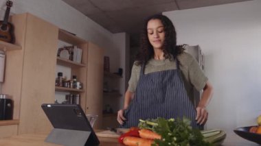 Afro-Amerikalı genç mutlu kadın mutfakta yemek yapmaya hazırlanıyor. Aileye yemek hazırlıyor. 