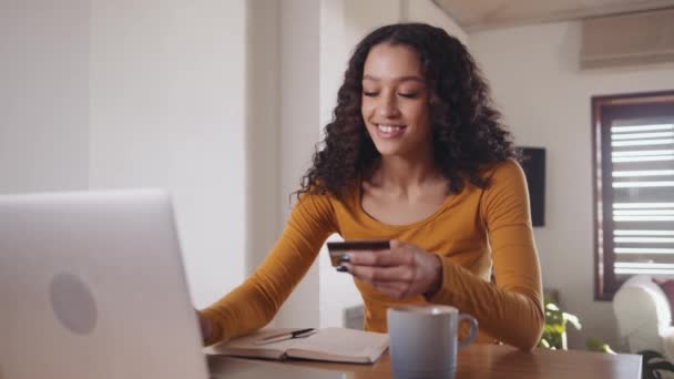 Africano América estudante do sexo feminino trabalhando em casa usando laptop para fazer o pagamento on-line com cartão de crédito — Vídeo de Stock