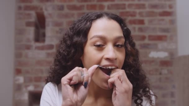 Zdravá multikulturní mladá žena, která si čistí zuby v moderním koupelnovém zrcadle. Dívat se na fotoaparát jako zrcadlo — Stock video
