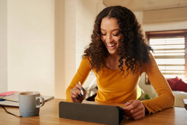 Yaratıcı Afro-Amerikan kadın serbest çalışan mutlu bir şekilde evinde dijital tablet çiziyor.