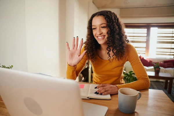 Afrikansk-Amerikas kvinnelige forretningskvinne vinker på laptop mens hun er på forretningssamtale med kunder – stockfoto