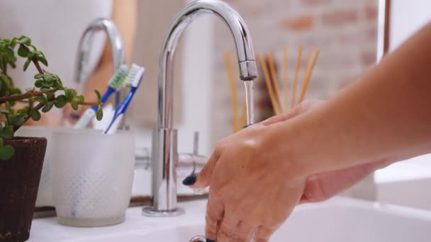 Close up of hands, multicultural female washing her hands thoroughly under tap in modern bathroom. — Stock Video