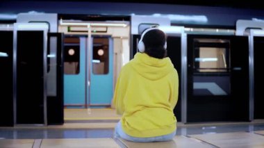 Trenin istasyona varmasını bekleyen genç bir kadın trene biner.