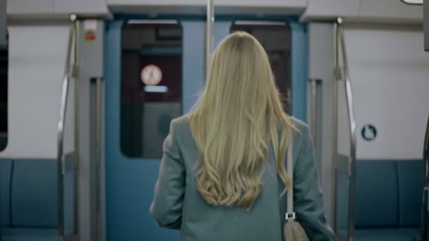 Блондинка їде в сучасний поїзд, знайомиться зі своїм другом. — стокове відео