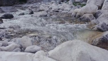 Dağ nehrinin yavaş akıntısı. Resimli bir manzara. Etrafında beyaz taşlar.
