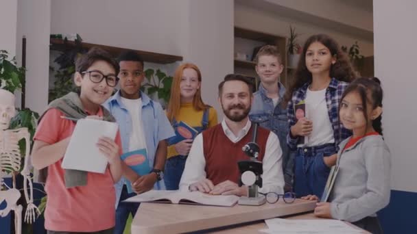 Férfi tanár általános iskolás gyerekekkel, akik kamerába néznek és mosolyognak — Stock videók