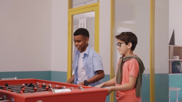 Children playing table football at break in school jumping for joy of winning — Stock Video