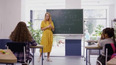 Bayan öğretmen çocuklara büyük bir heyecan ve ilgiyle ders veriyor.