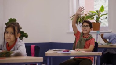 Çocuk soruyu elini kaldırarak cevaplamak istiyor, üzülüyor. İlkokul