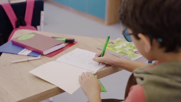 Обережний хлопчик малює в уроці геометрії з лінійкою та олівцем, початкова школа — стокове відео